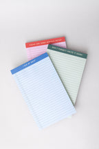 Three mini legal pads in blue, pink, and green, each featuring a unique header phrase.