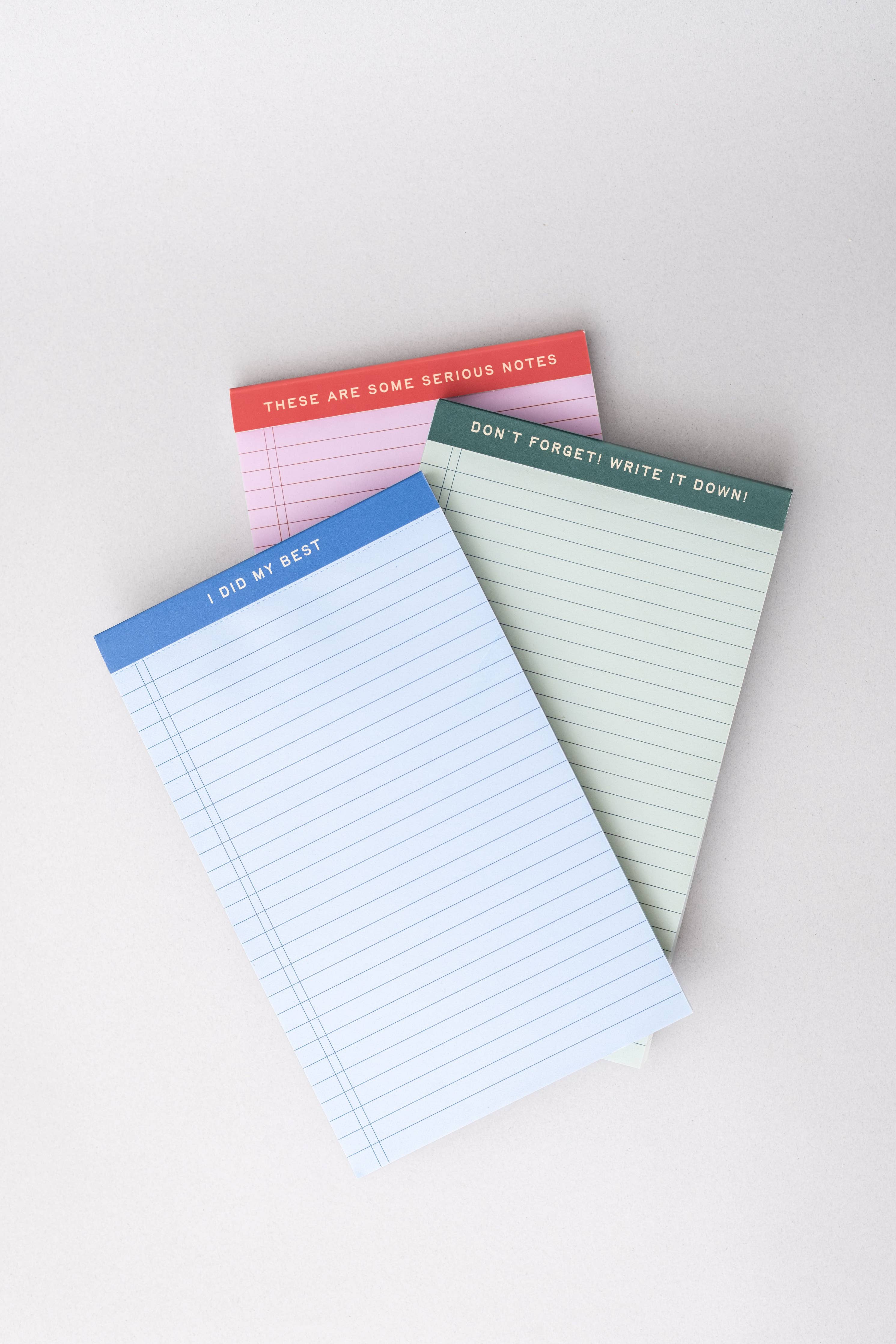 Three mini legal pads in blue, pink, and green, each featuring a unique header phrase.